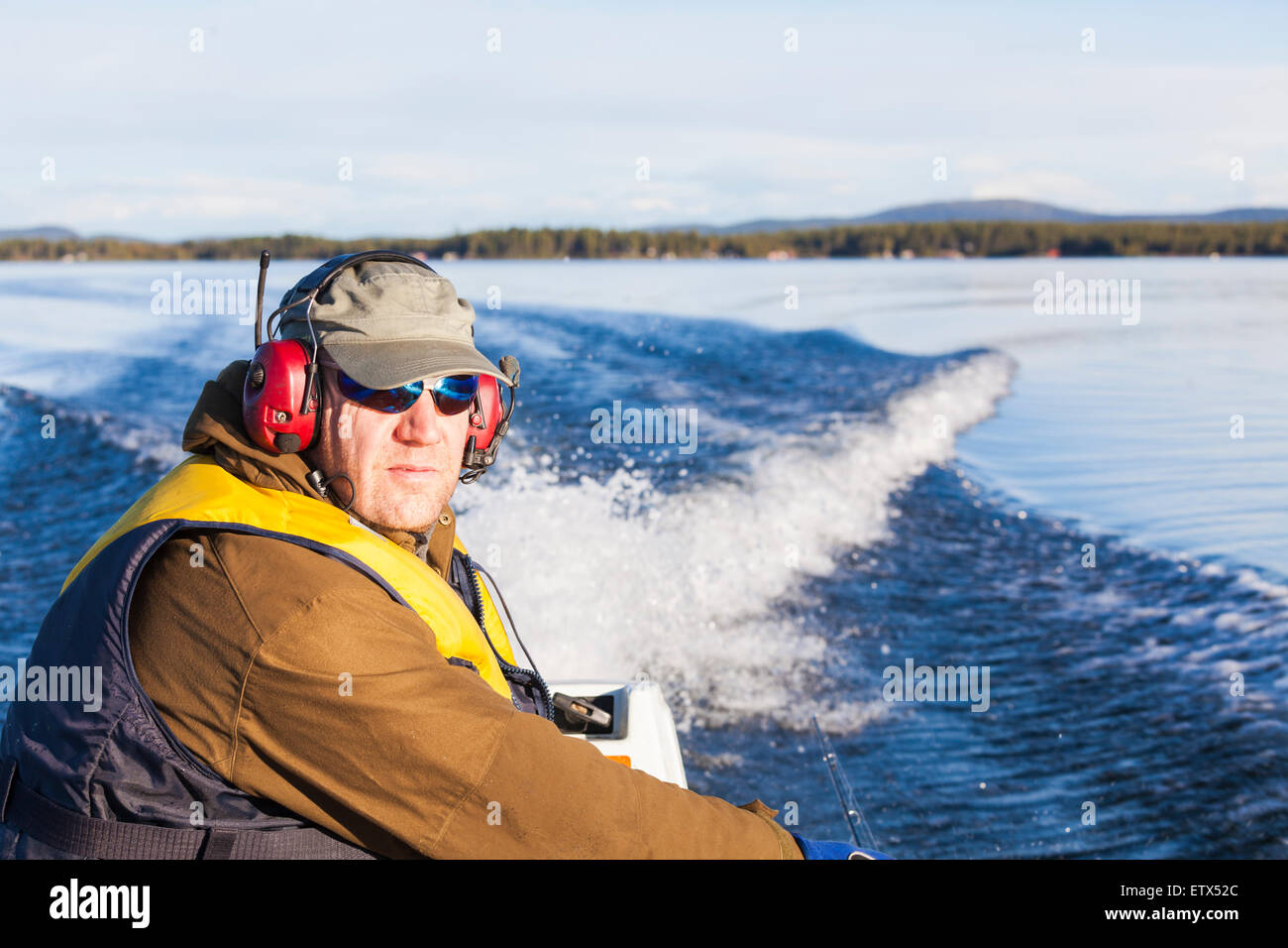 White man, 45-50 years old driving boat in jukkasjärvi, Sweden, Swedish lapland Stock Photo