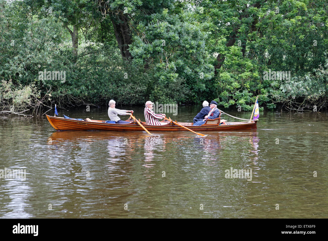 On the River Thames at Runnymede a rowboat works its way upstream Stock Photo