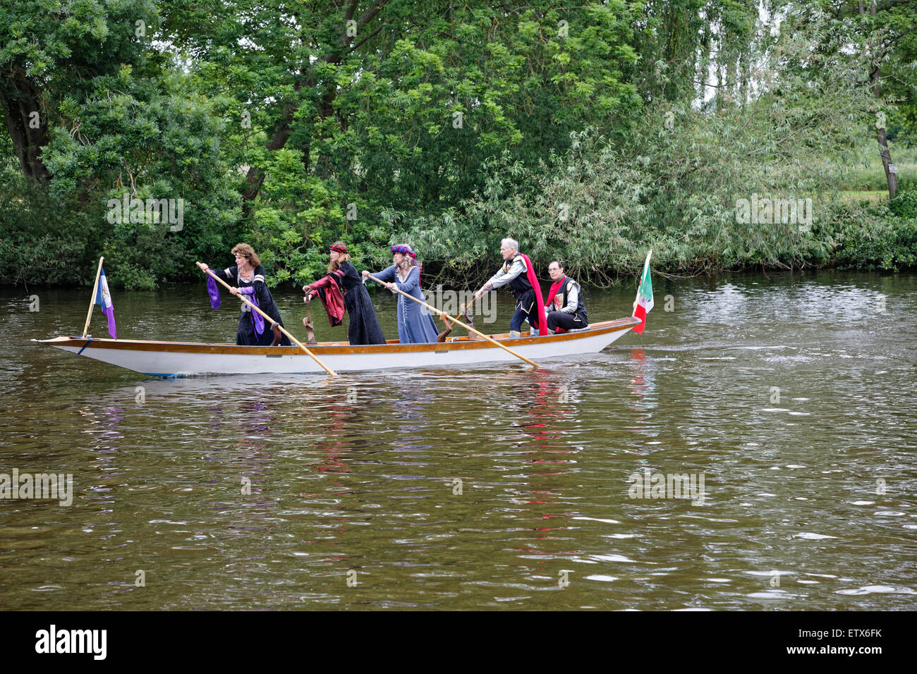 On the River Thames at Runnymede a boat with costumed crew is rowed