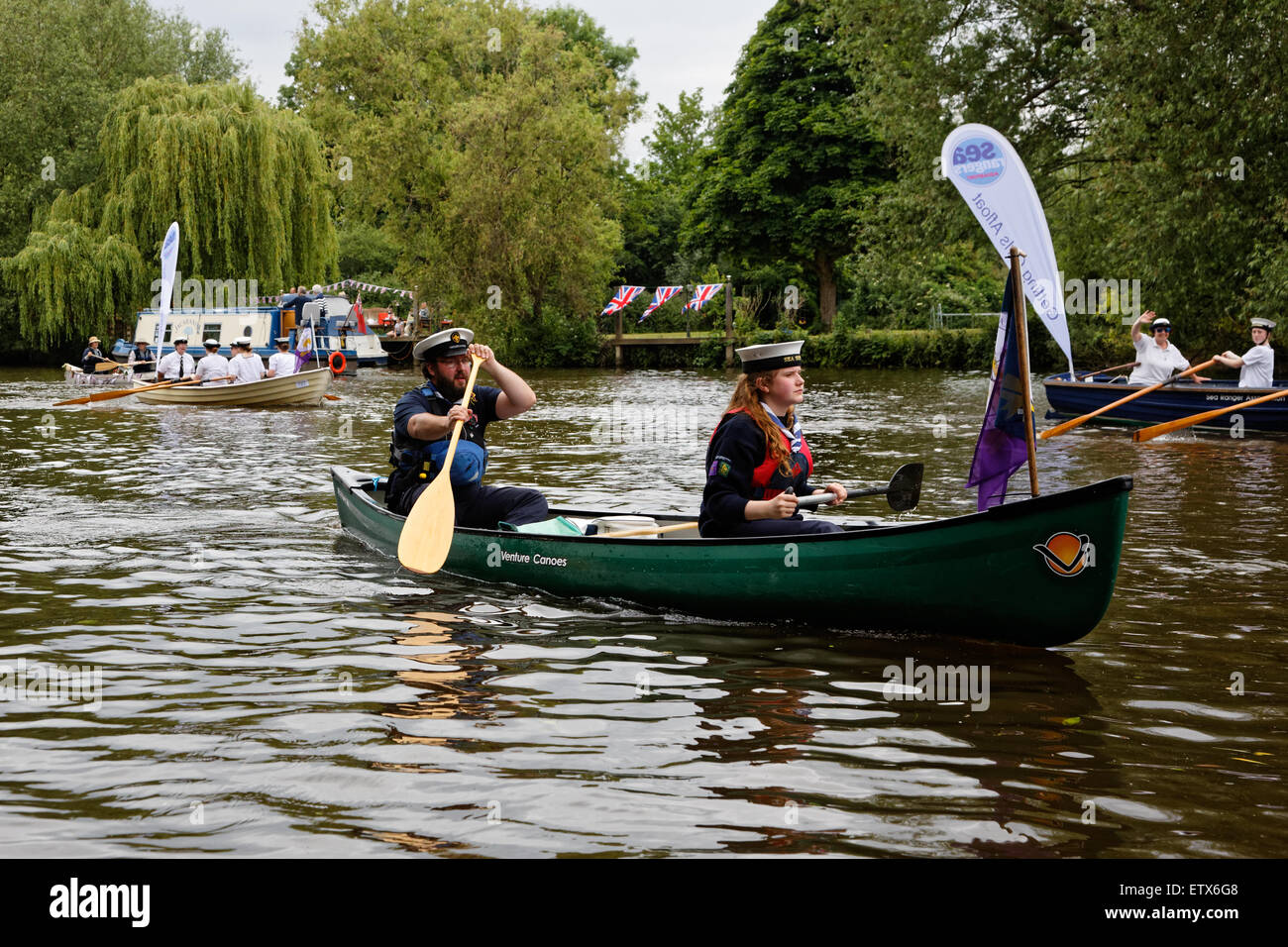On the River Thames at Runnymede uniformed sea scouts, man and young woman, paddle a canoe downstream Stock Photo
