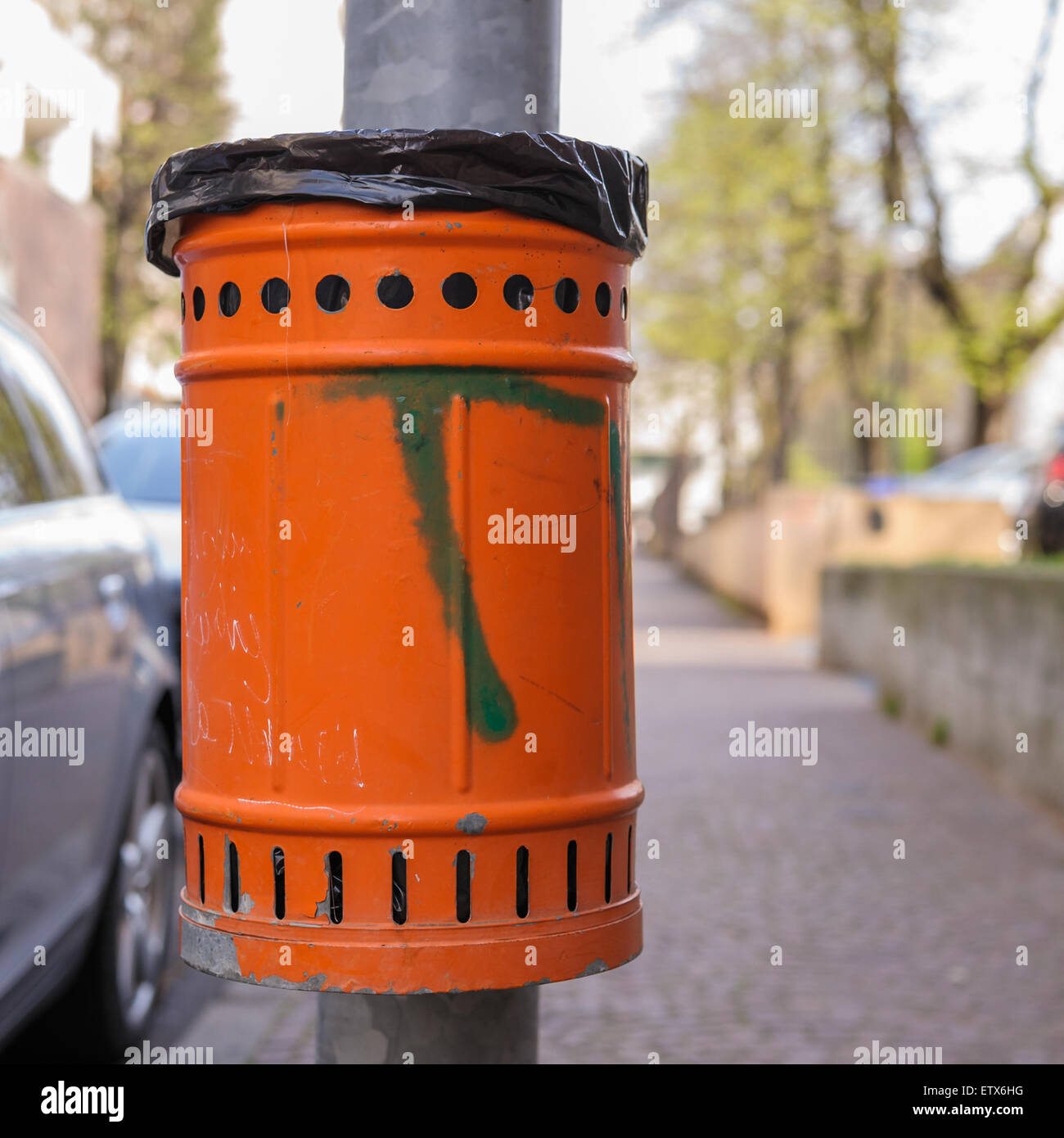 Trash orange metal for the collection of waste of the road Stock Photo