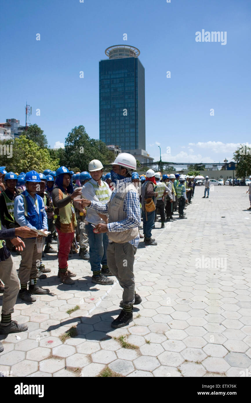 Construction workers take part in stretching exercises to enhance ...