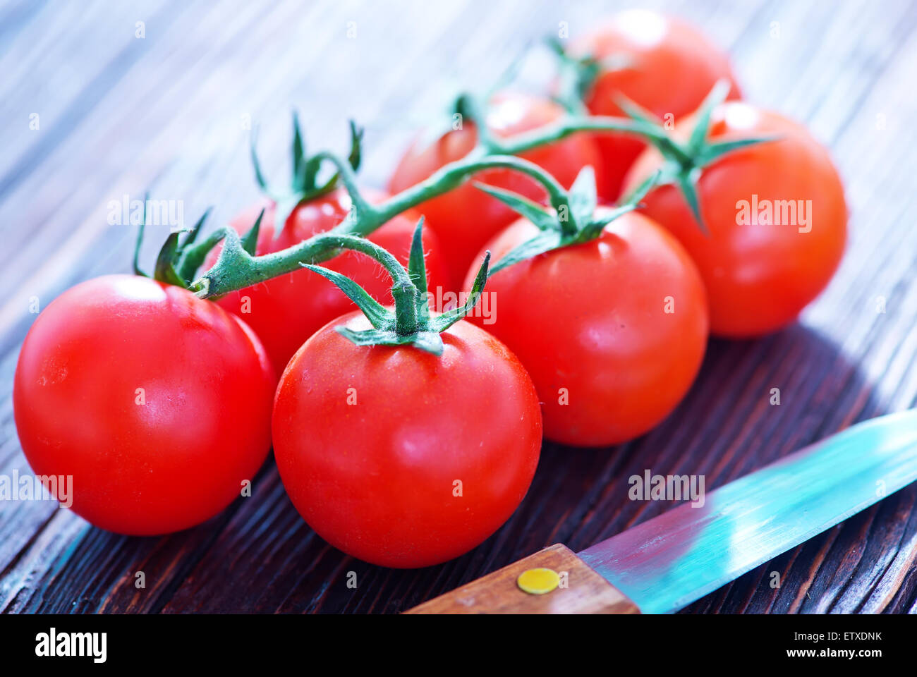 tomato cherry and knife on tha wooden table Stock Photo - Alamy