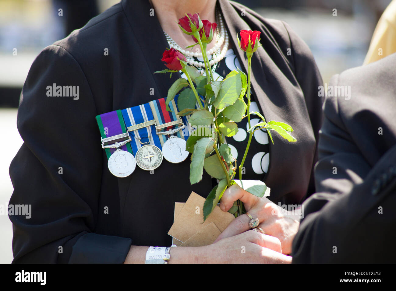A Guest arriving at the Bastion dedication service at the National Memorial Arboretum carrying roses Stock Photo