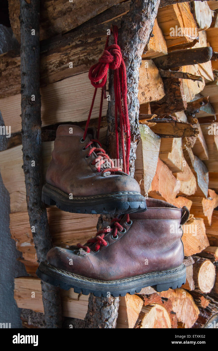 old brown boots on woodpile background red laces Stock Photo - Alamy