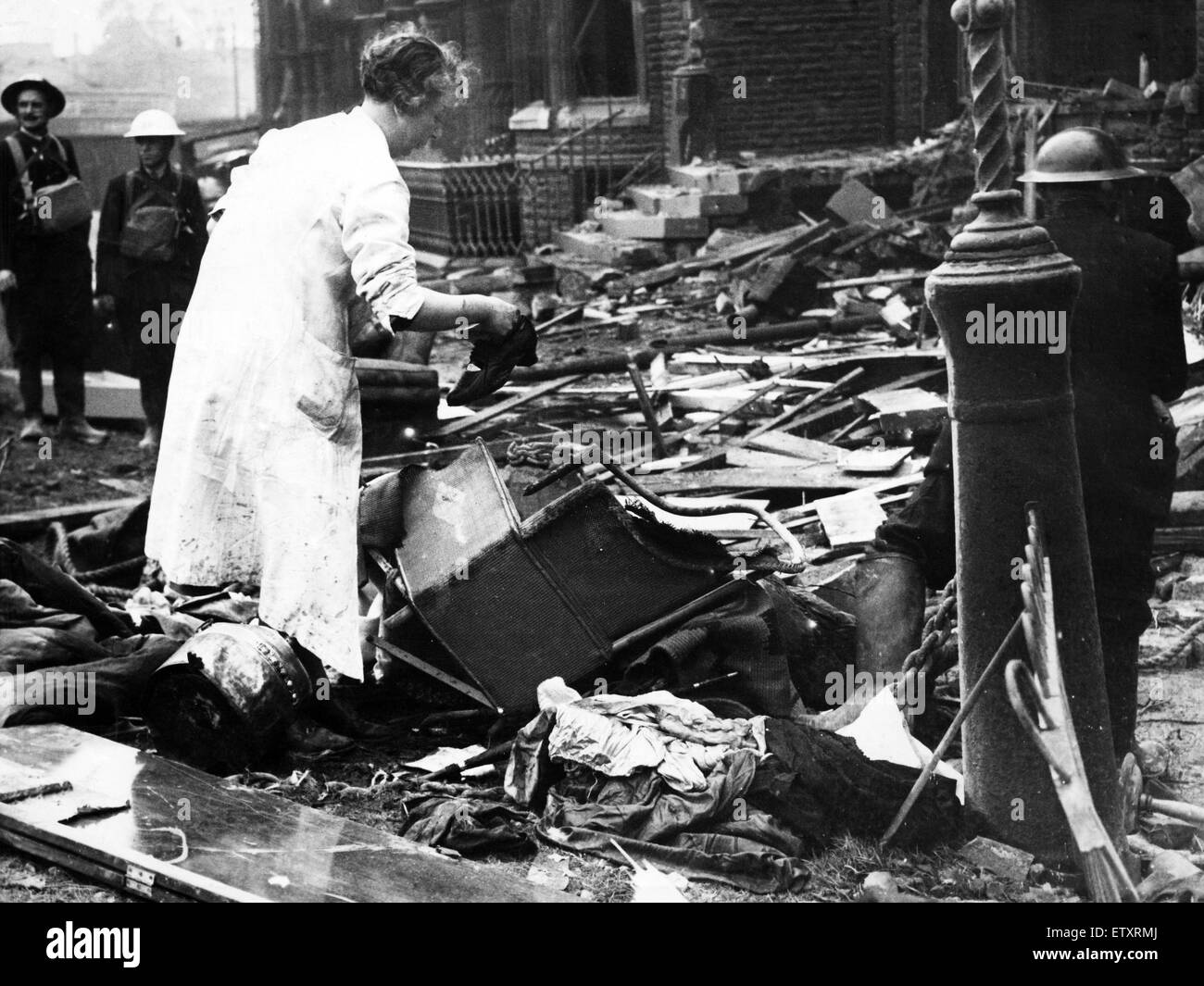 Bomb damage in Liverpool during the Second World War.  A woman searches the wreckage of her home for belongings, after a German raider had dropped bombs on it during a raid to a block of flats in Belvidere Road, Liverpool. 27th September 1940. Stock Photo