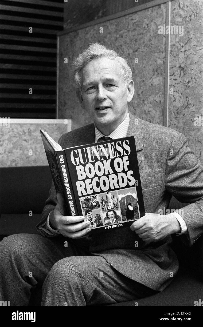 Norris McWhirter holding a copy of the Guinness Book of records, which he co-founded with his brother Ross, on a visit to Birmingham. 20th October 1982. Stock Photo