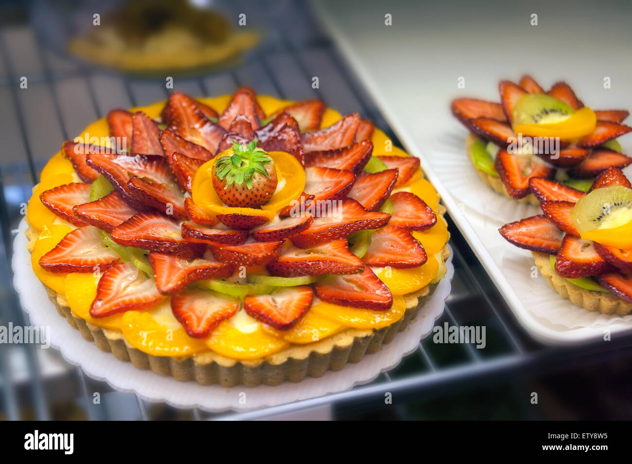 Fruits Tart and Pie with Sliced Strawberry Peach and Kiwi on top of Crust Closeup Stock Photo