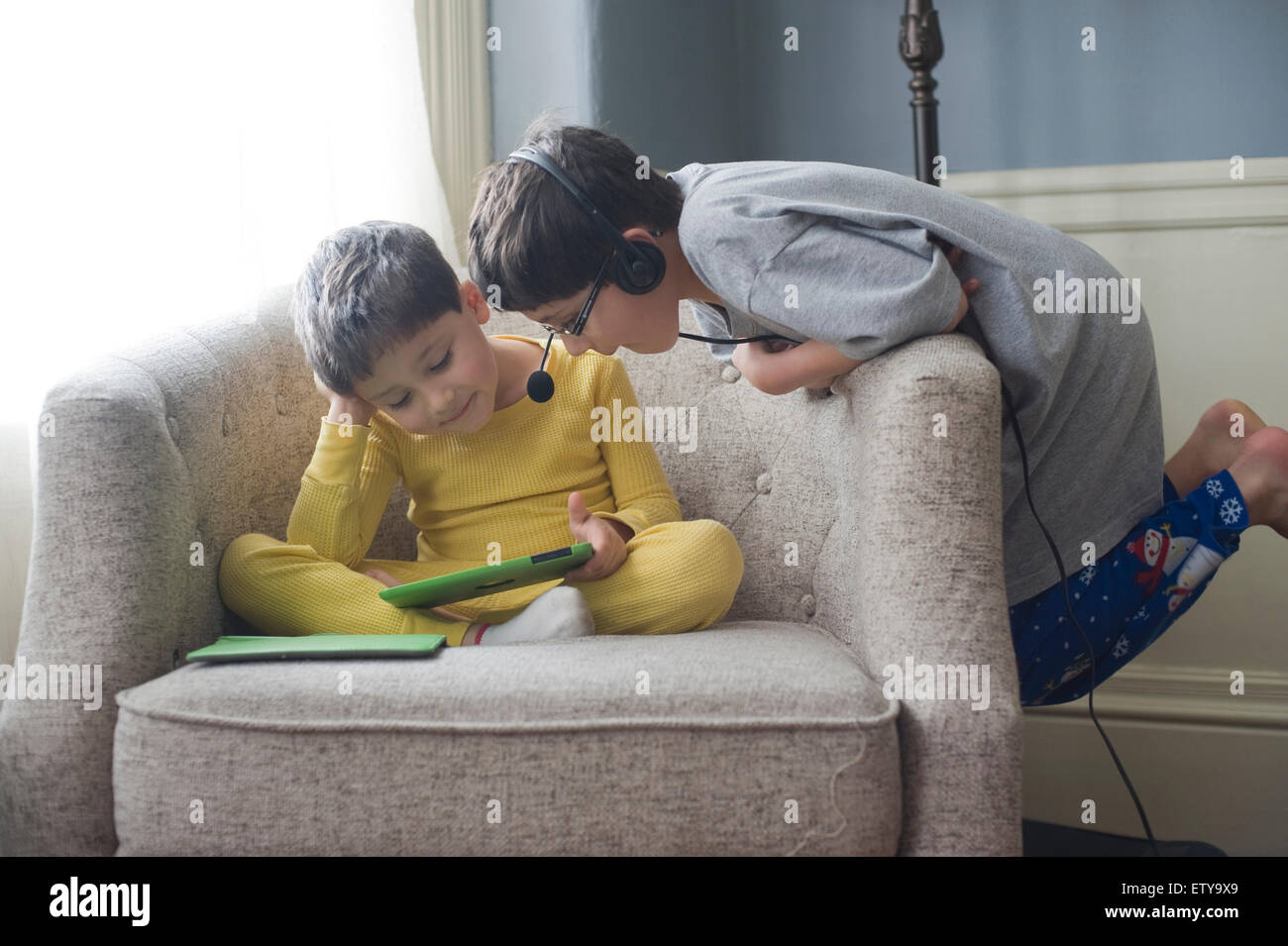 Brothers, ages 5 and 8 look at videos on Ipad mini Model Released / MR Stock Photo
