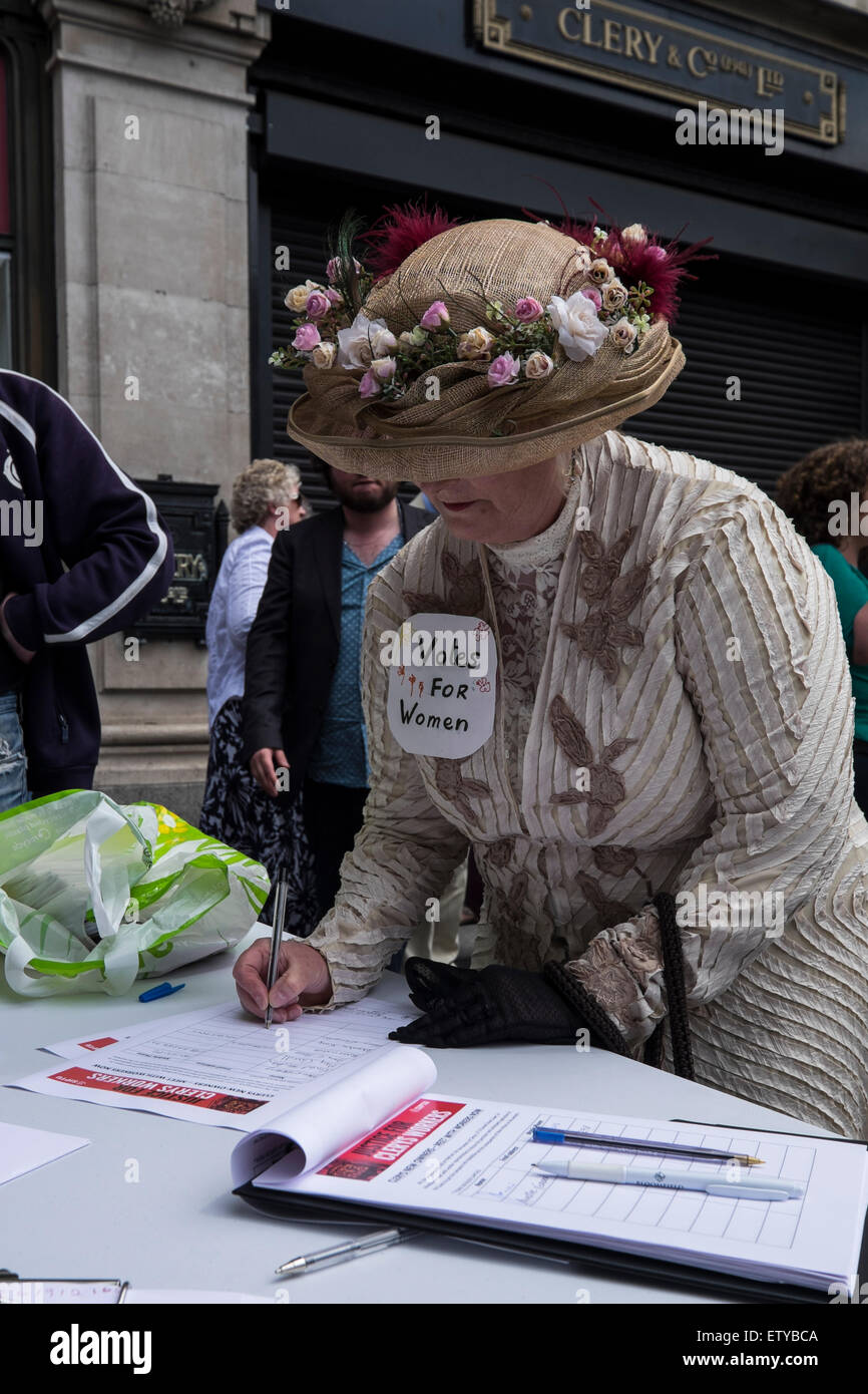 O' Connell Street, Dublin, Ireland. 16 June 2015.A woman in 1920s style  dress for Bloomsday signs a petition at a demonstration outside Clery's  department store to support workers who have been laid