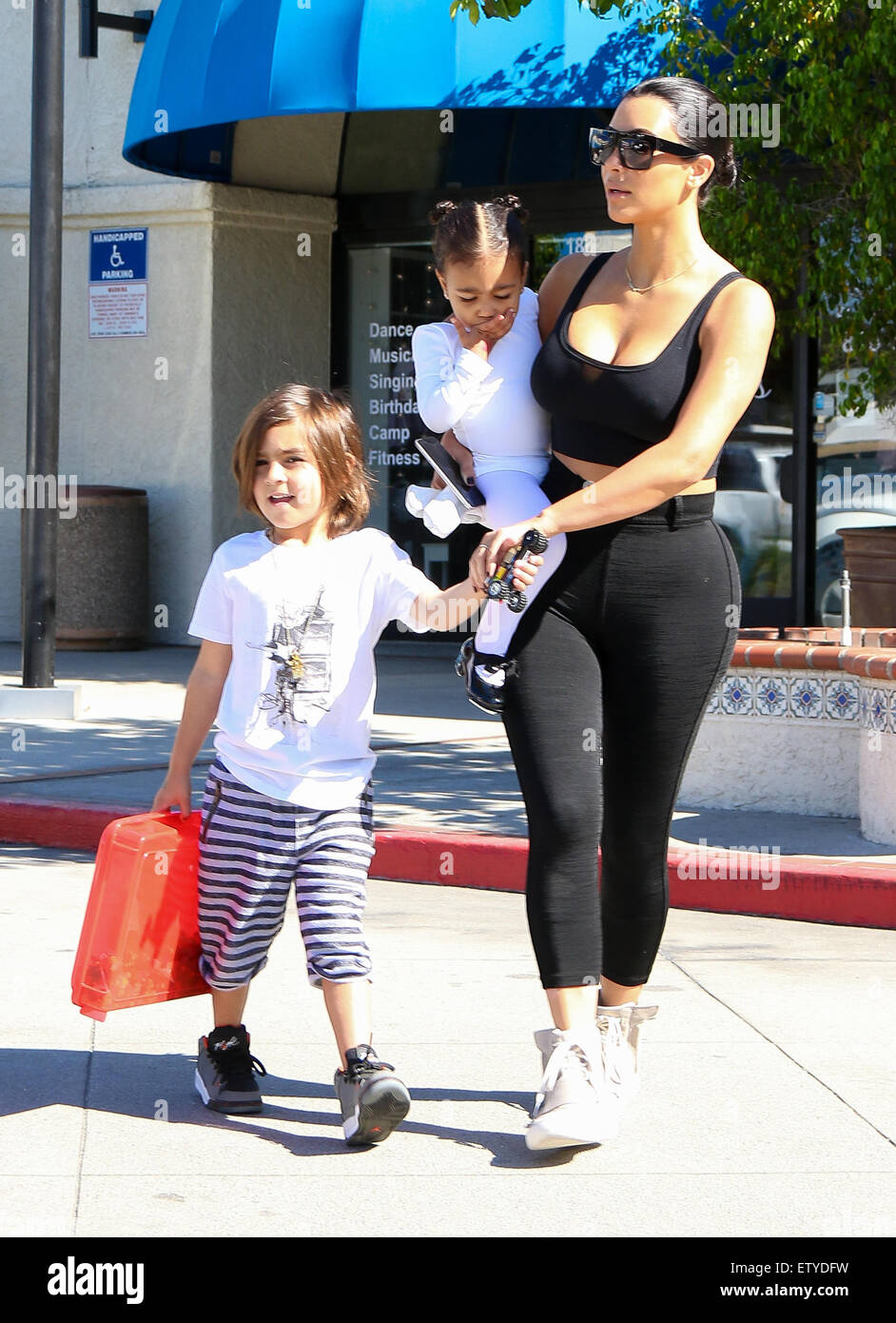 Kim Kardashian is back to black hair as she and Kourtney take their kids to ballet in Woodland Hills. Kim s sporting a pair of Adidas Yeezy Boost sneakers designed by Kanye West
