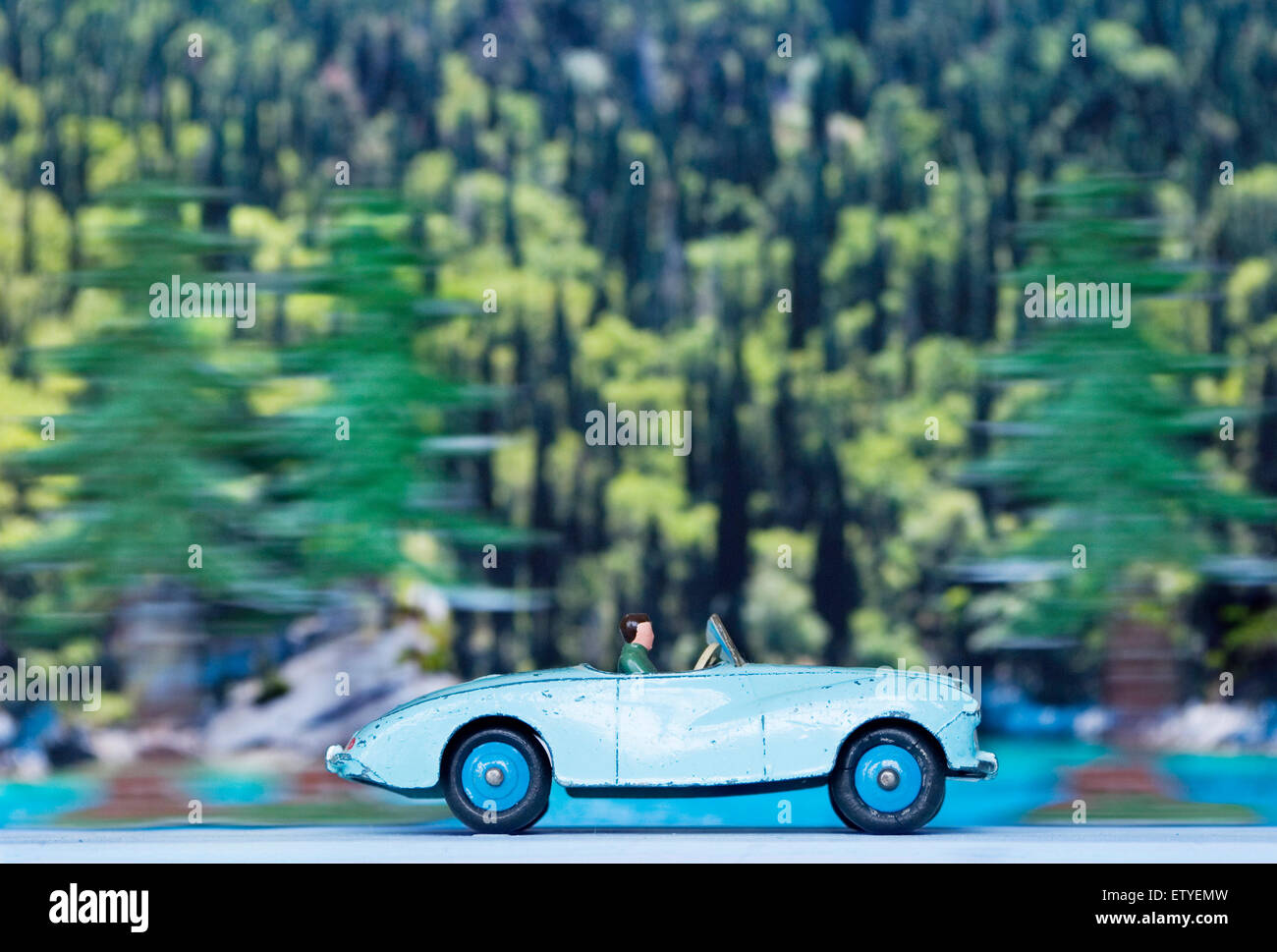 Dinky toy sports car speeding through an alpine forest Stock Photo