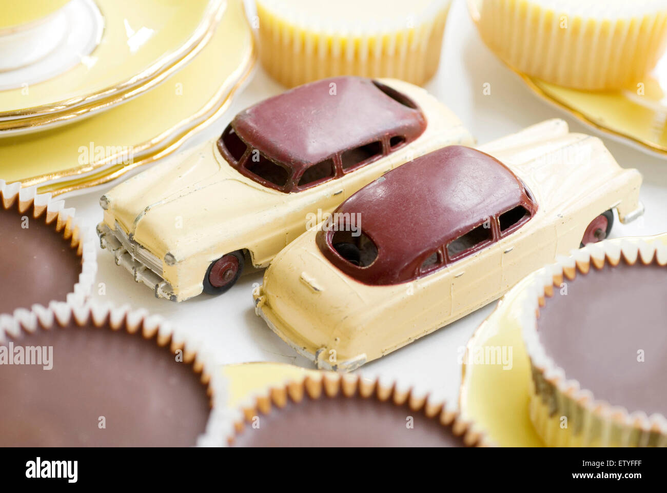 Pair of Dinky cars surrounded by cup cakes of a similar colour Stock Photo