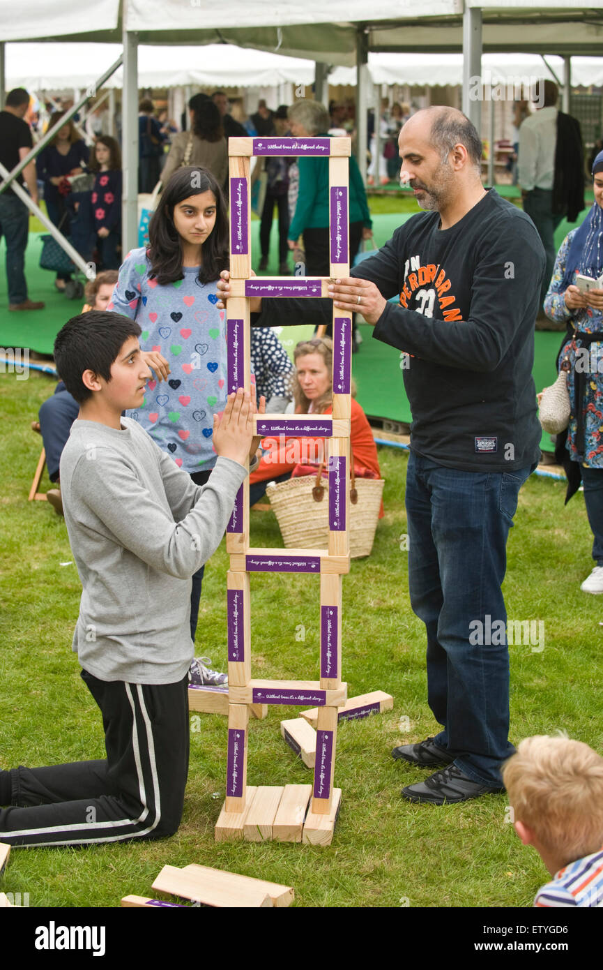 Visitors building a wooden balanced structure by The Woodland Trust at Hay Festival 2015 Stock Photo