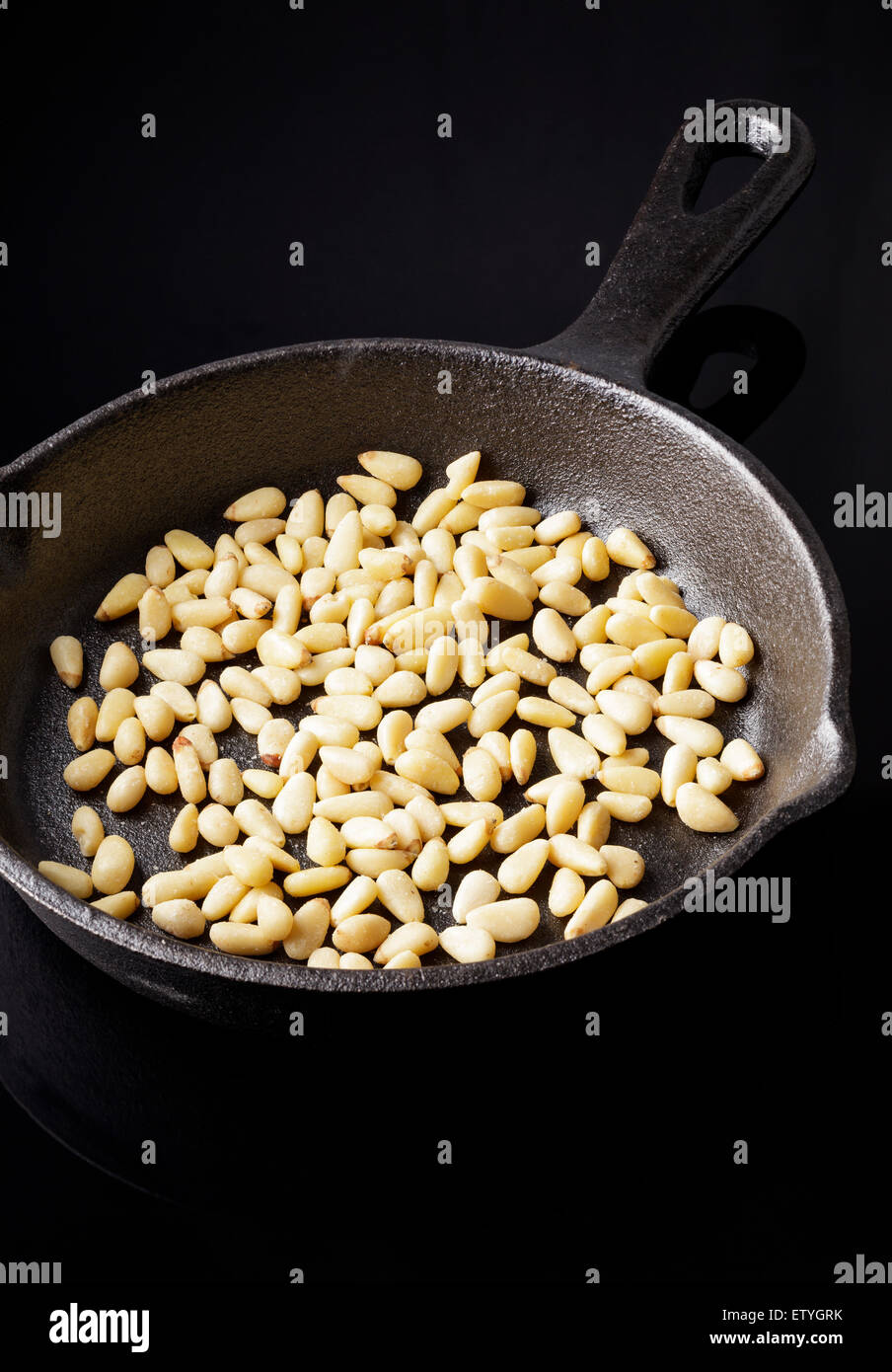 Pine Nuts in cast iron pan Stock Photo