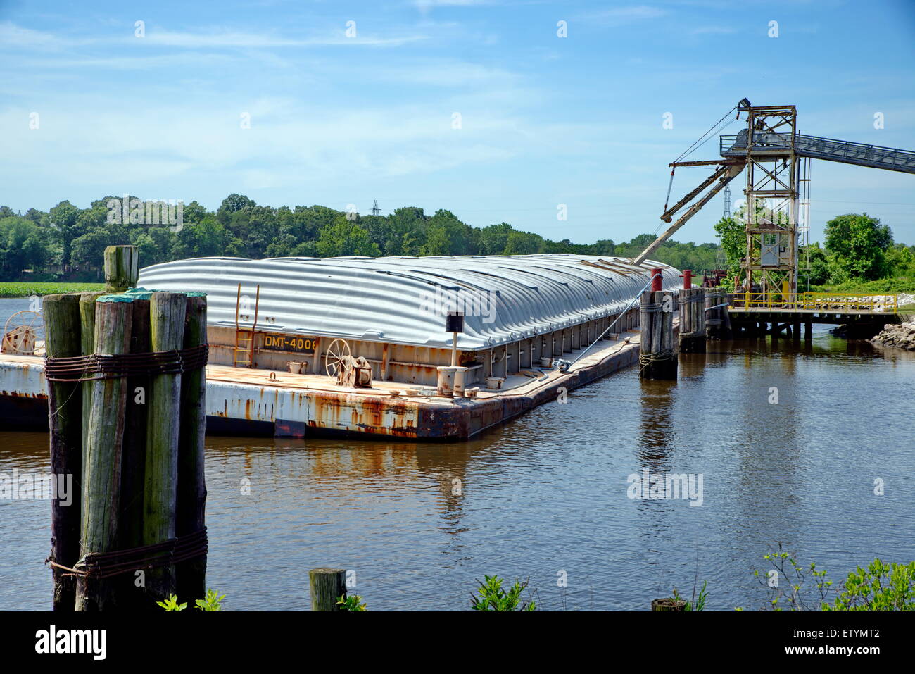 A loaded, covered grain barge sits near a dock along the Nanticoke River in Seaford, Delaware. Stock Photo