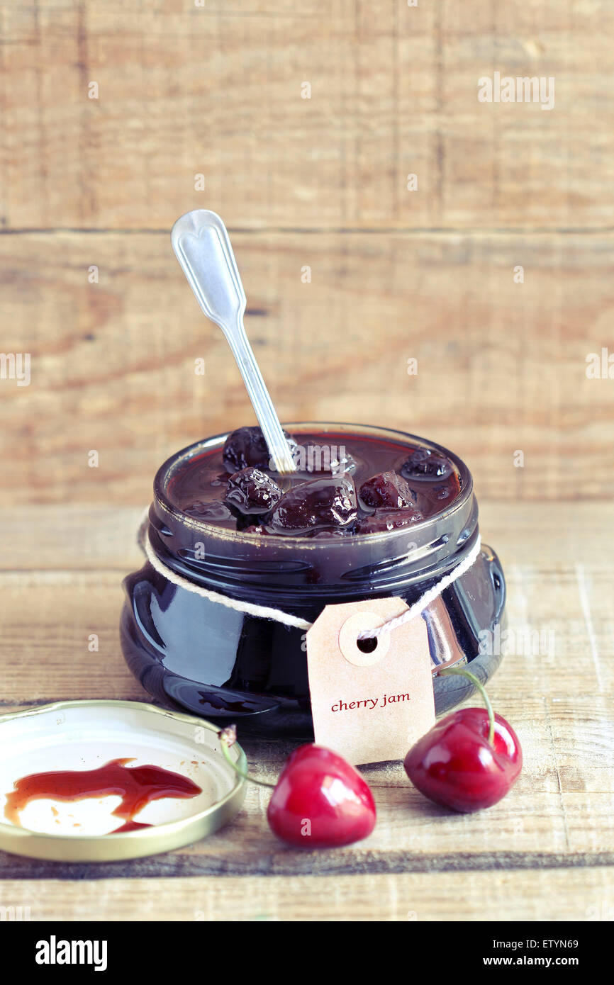 Cherry jam in a glass jar with label Stock Photo Alamy