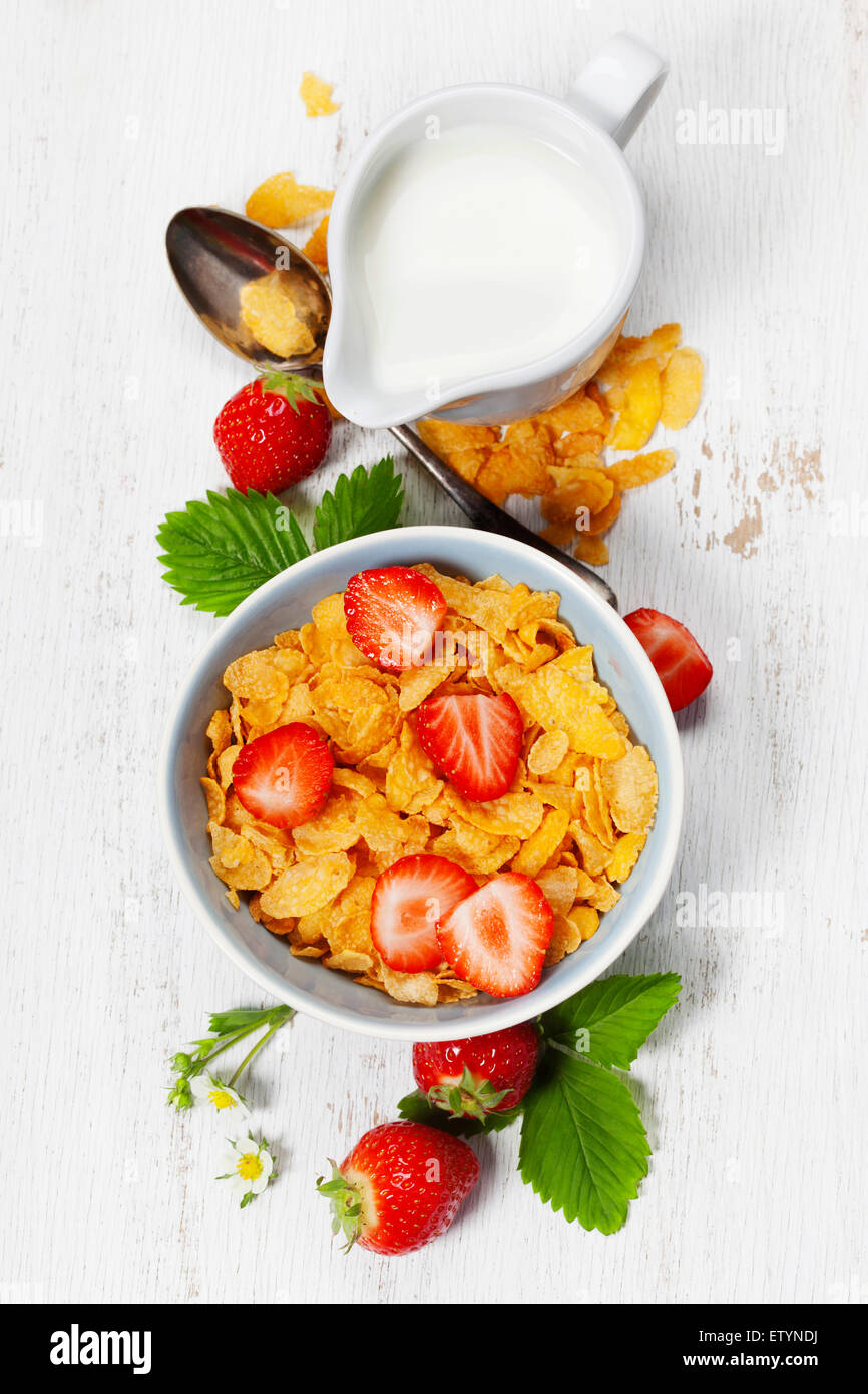 Healthy Breakfast with corn flakes, milk and strawberry on old wooden background. Health and diet concept Stock Photo