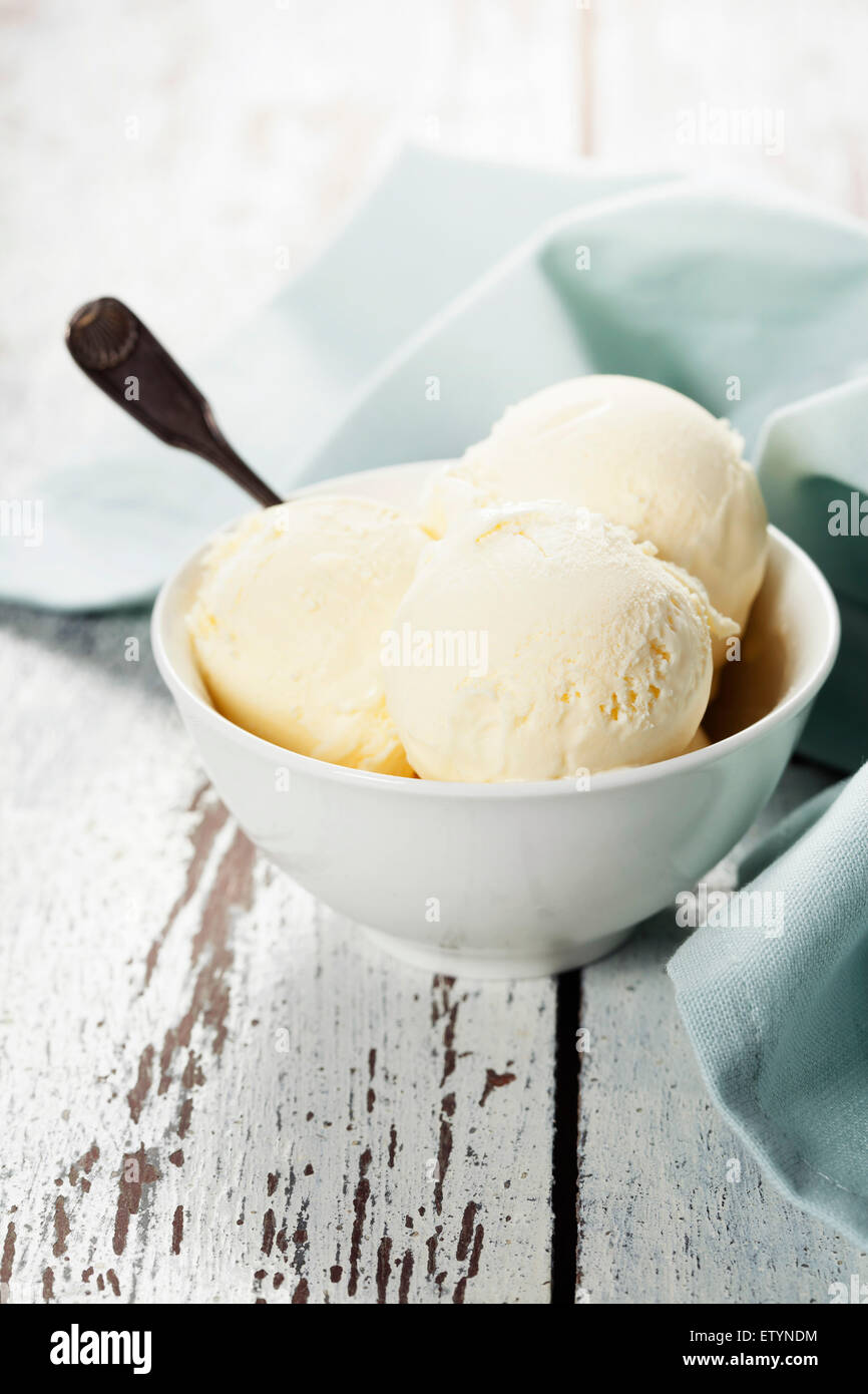 Vanilla icecream scoops in white cup on wooden background Stock Photo