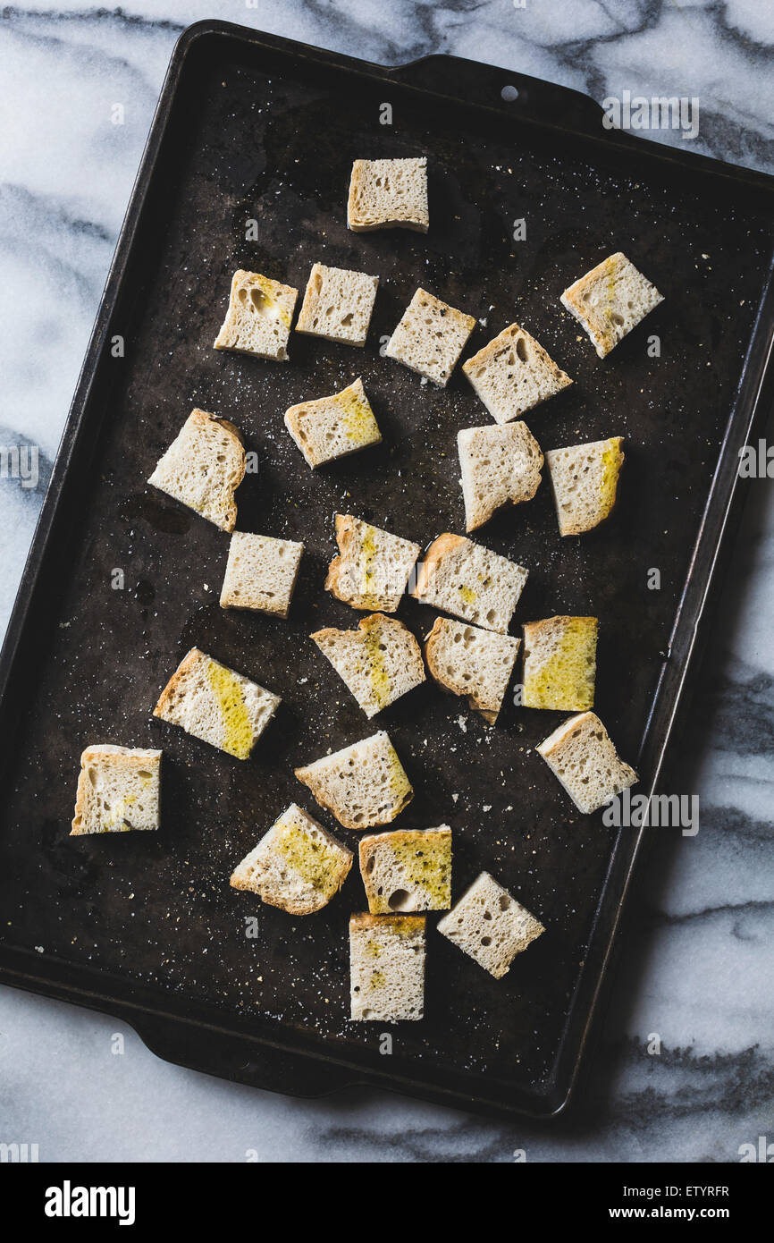 Croutons - crusty bread cubes covered in olive oil, about to be toasted. Stock Photo