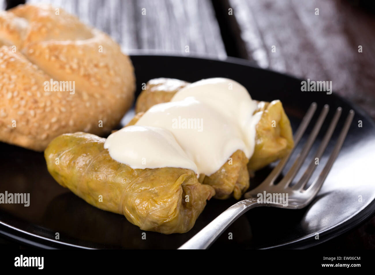 Cabbage rolls filled with minced meat and rice on plate with bread, over wooden table Stock Photo