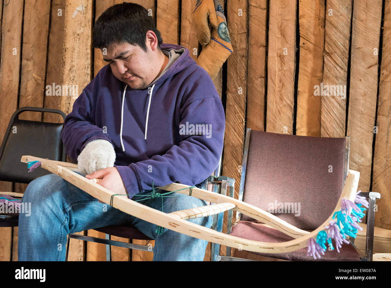 Young indigenous man making a traditional snowshoe , Northern Quebec, Canada Stock Photo