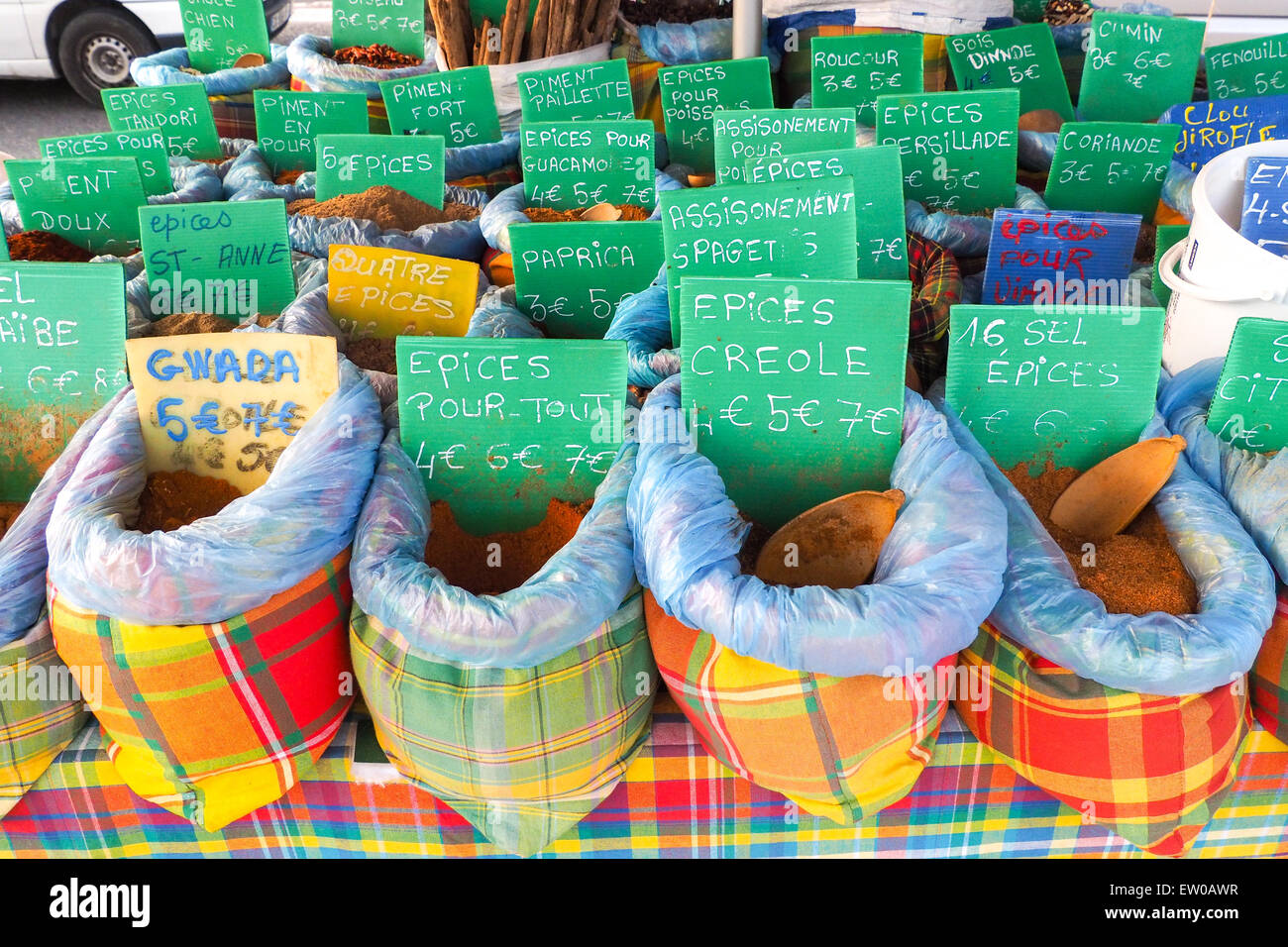 Several bags containing typical spices for cooking with tags reporting names and prices are exposed on a market stall Stock Photo