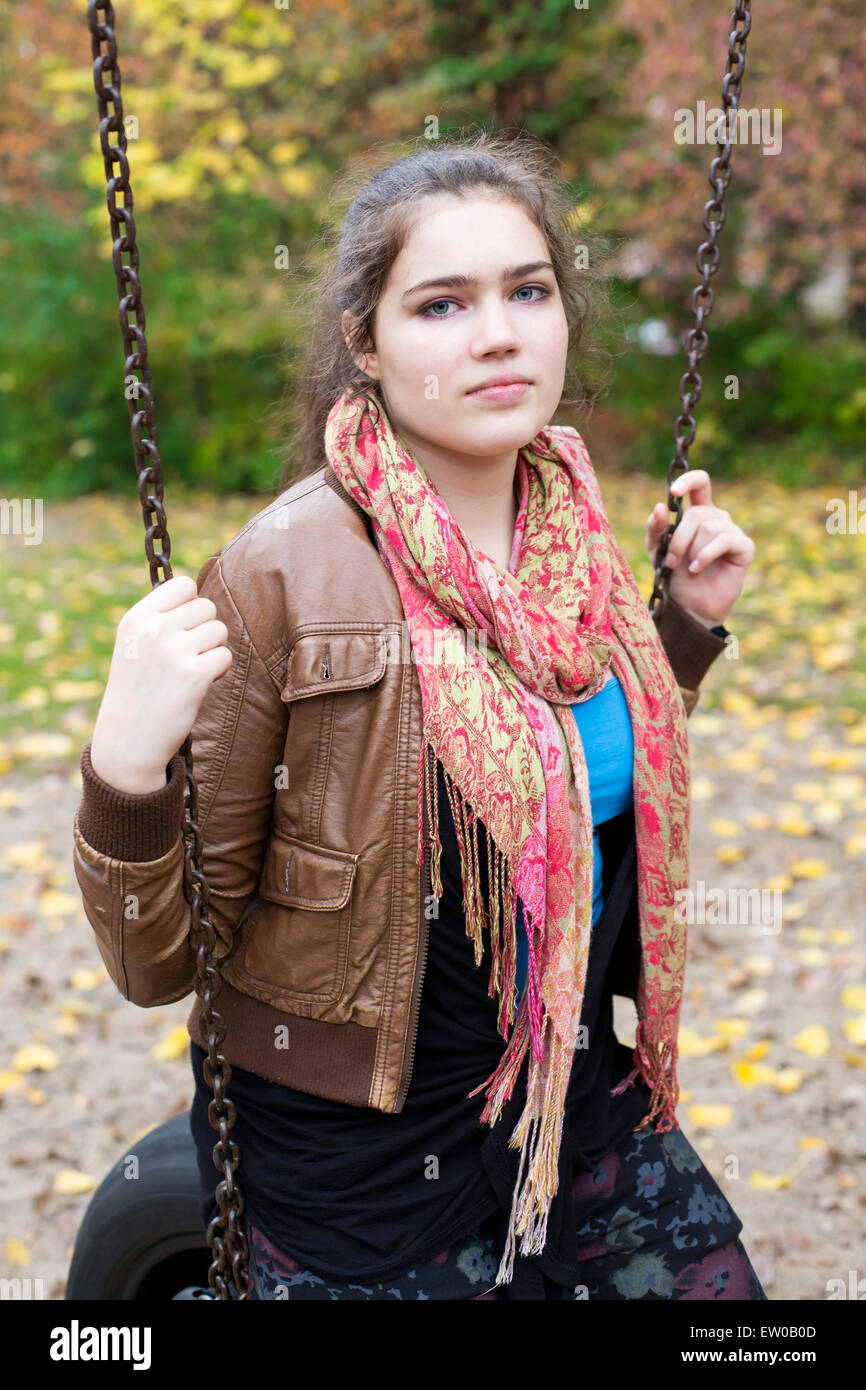 teenage girl sitting on a swing outside Stock Photo - Alamy