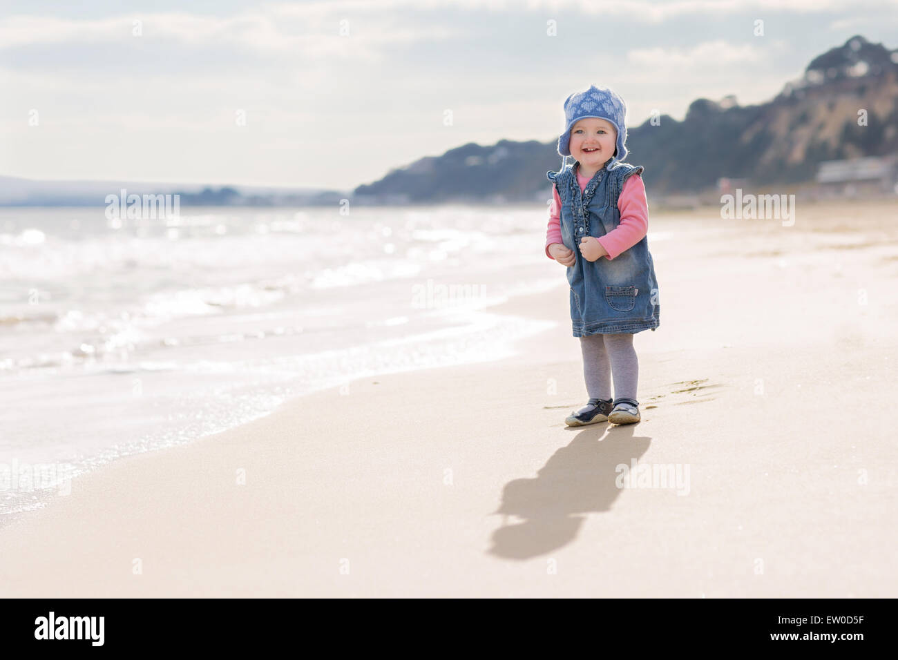 Girl toddler at beach with wearing winter hat Stock Photo