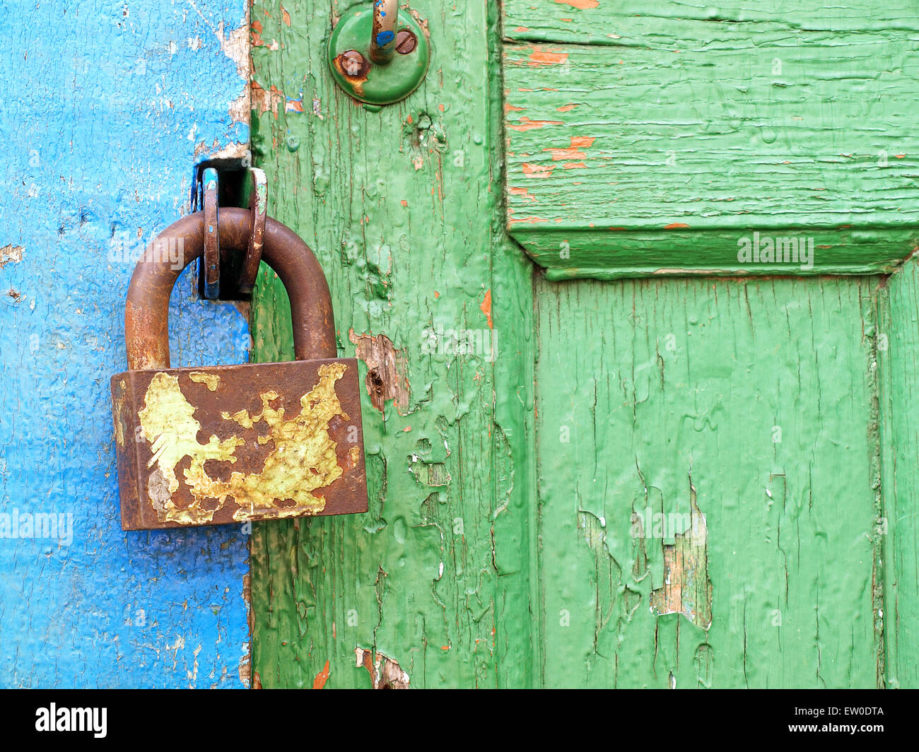 Old metal lock on a aged color wooden door taken closeup. Stock Photo