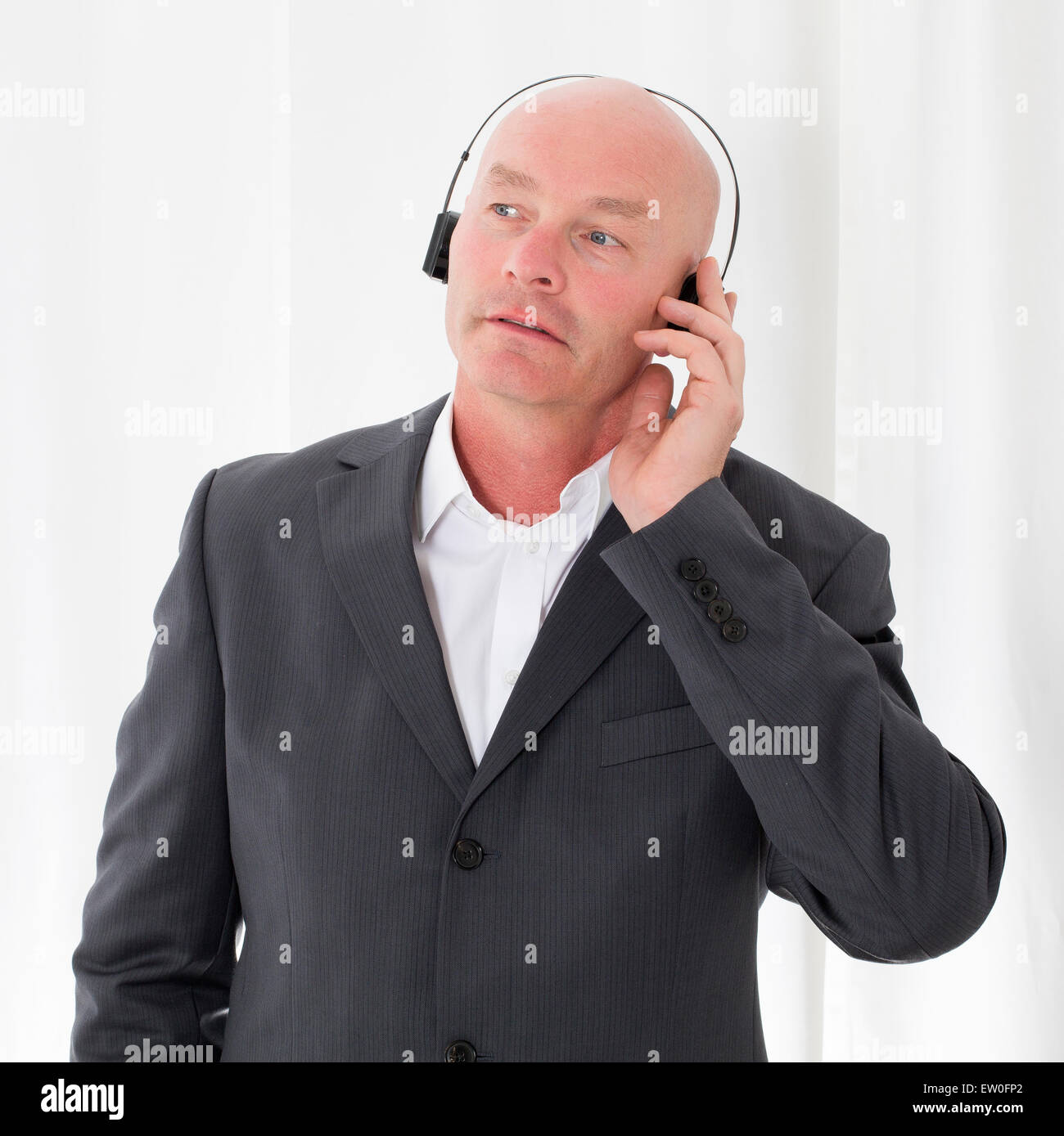 bald-headed businessman with headphones Stock Photo
