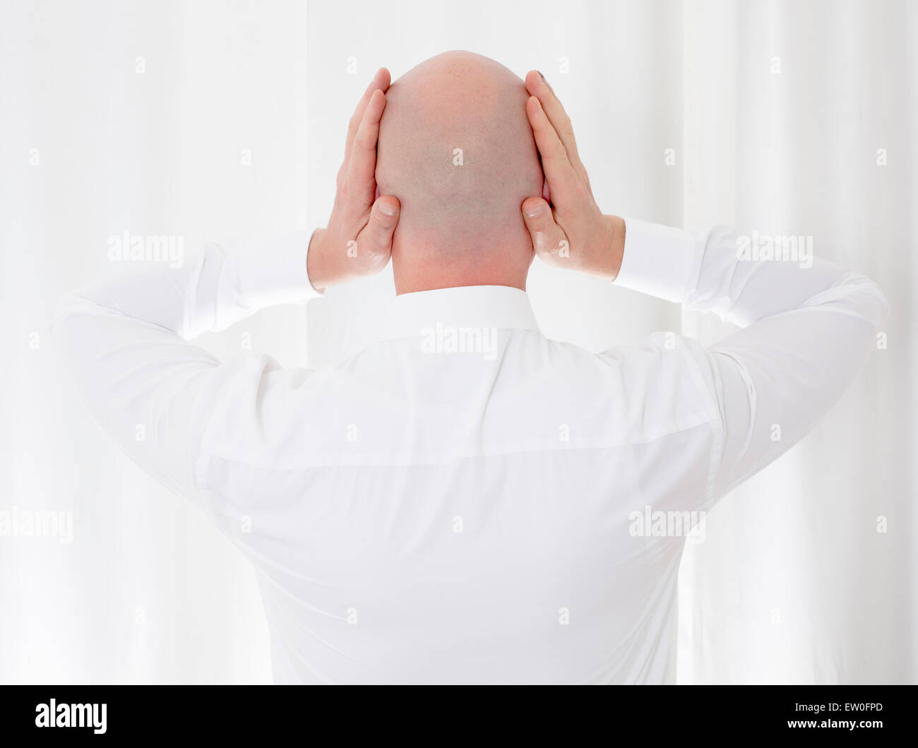 back of a bald-headed man in a white shirt Stock Photo