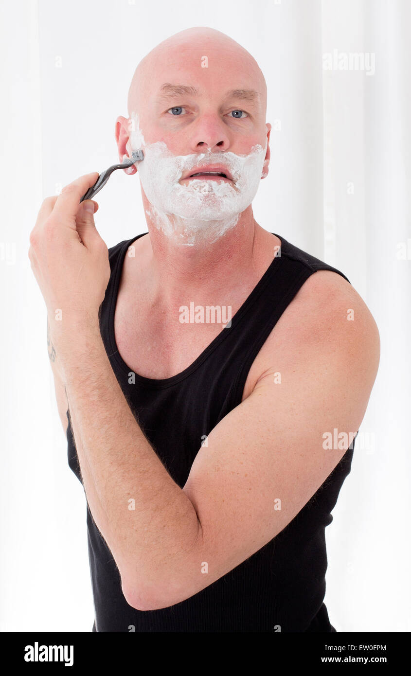 bald-headed man shaving Stock Photo