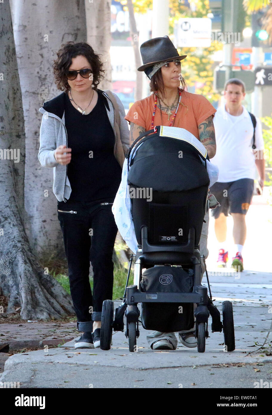 Sara Gilbert and wife Linda Perry take their newborn son Rhodes on a