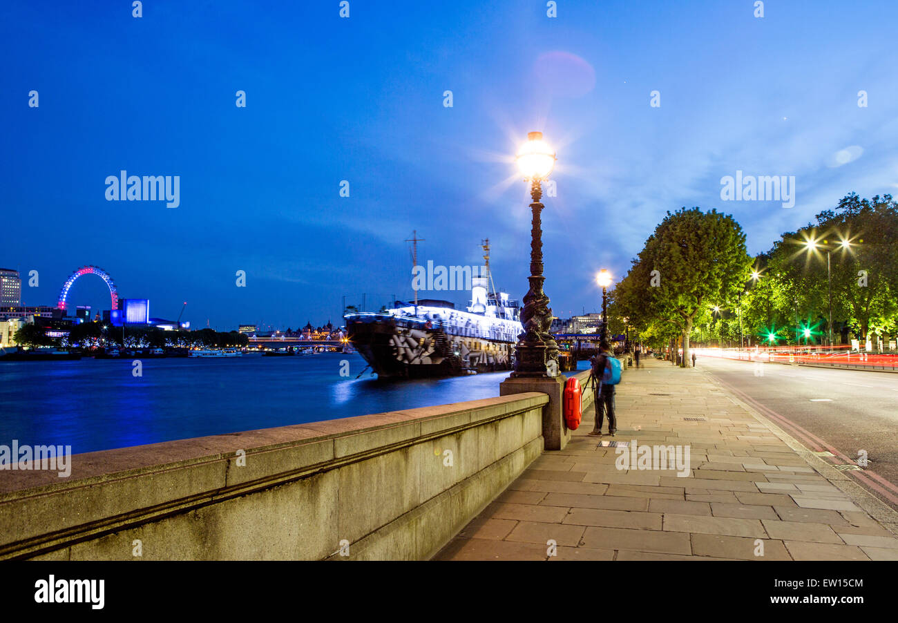 Victoria Embankment At Night With People and Boat London UK Stock Photo