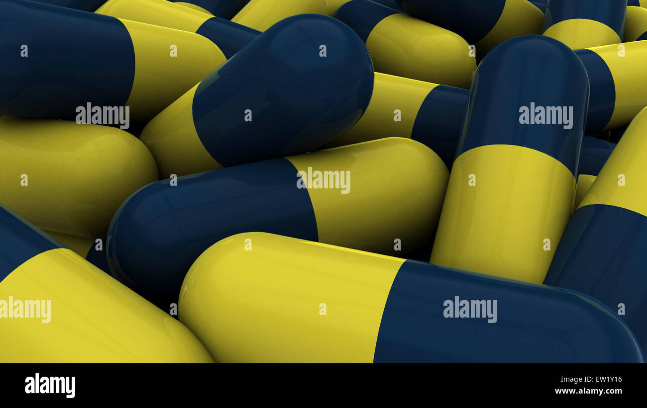 Pile of blue and yellow medication capsules. Stock Photo