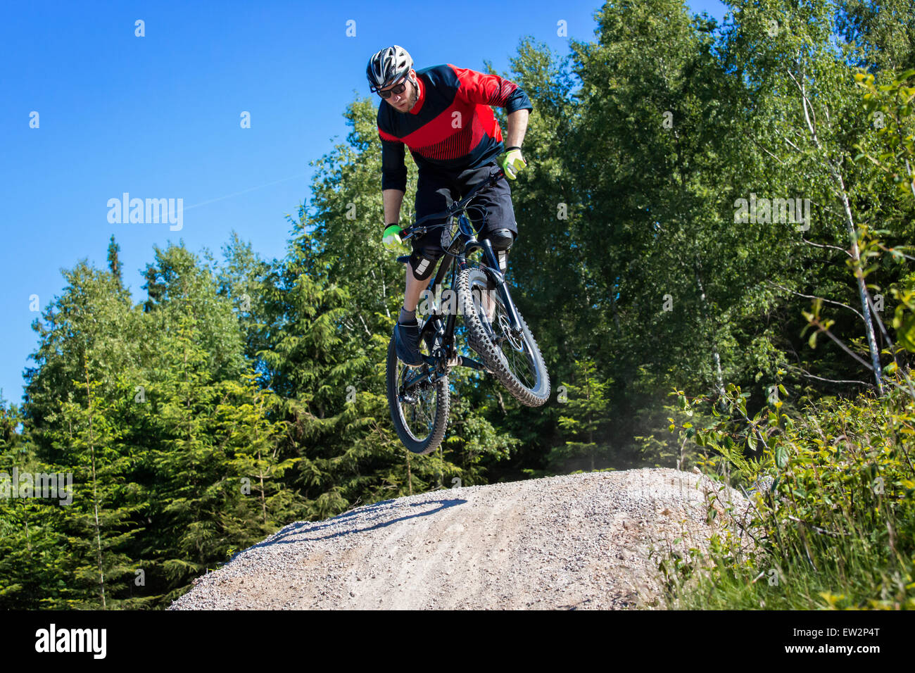 Mountain bike rider jumps over a dirt track kicker Stock Photo Alamy