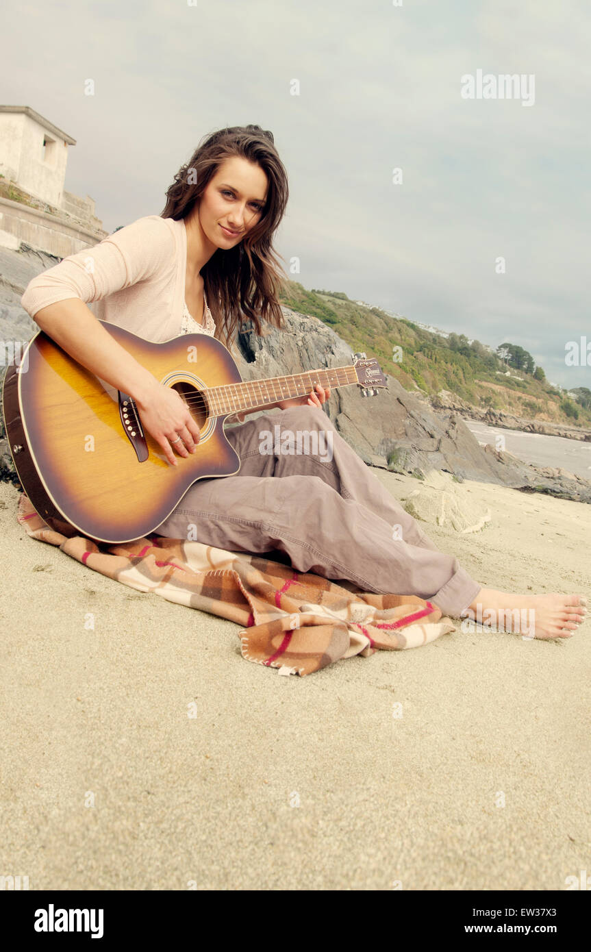 Young woman playing acoustic guitar on a beach Stock Photo - Alamy
