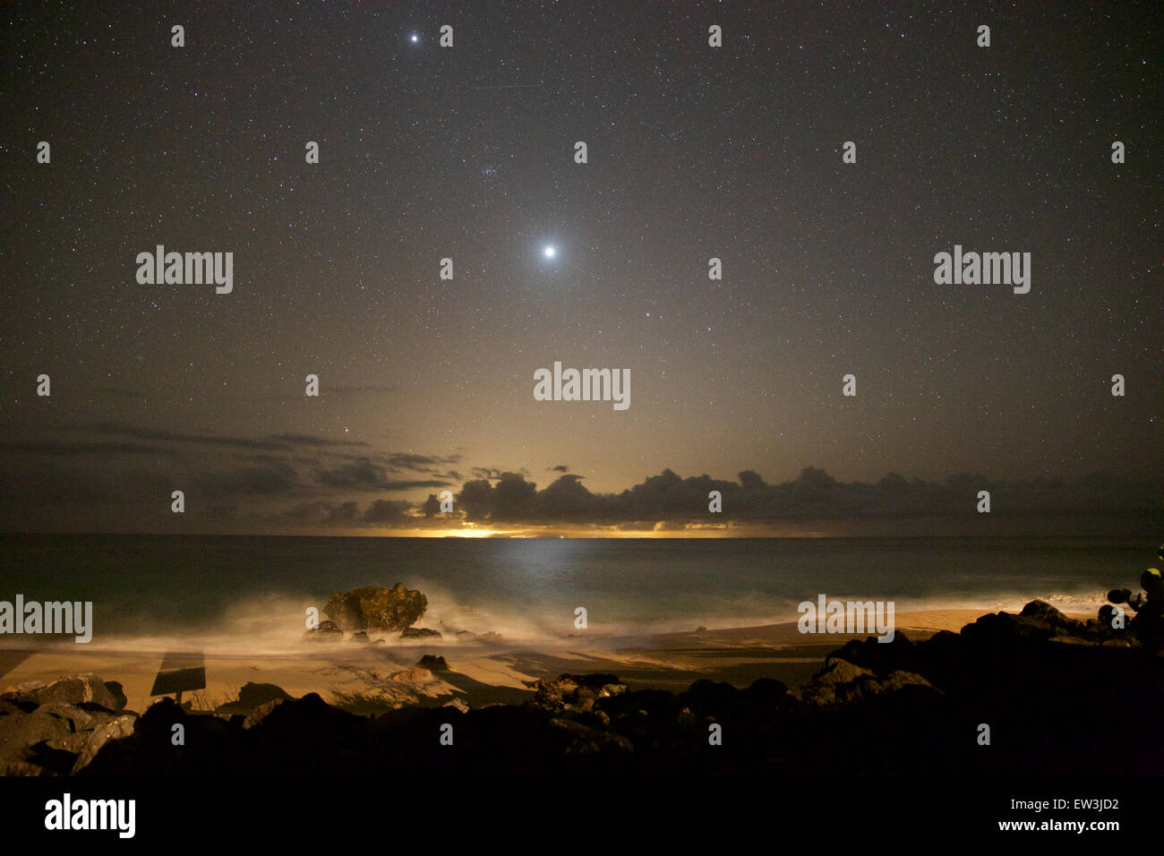 The night sky seen from the west coast of Molokai, looking towards Oahu and Honolulu.  The bright object in the center is Venus. Stock Photo