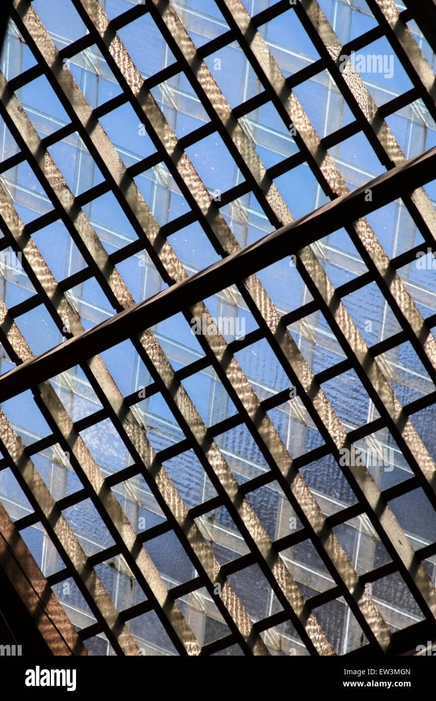 a lattice patterned glass and wood roof with blue sky Stock Photo