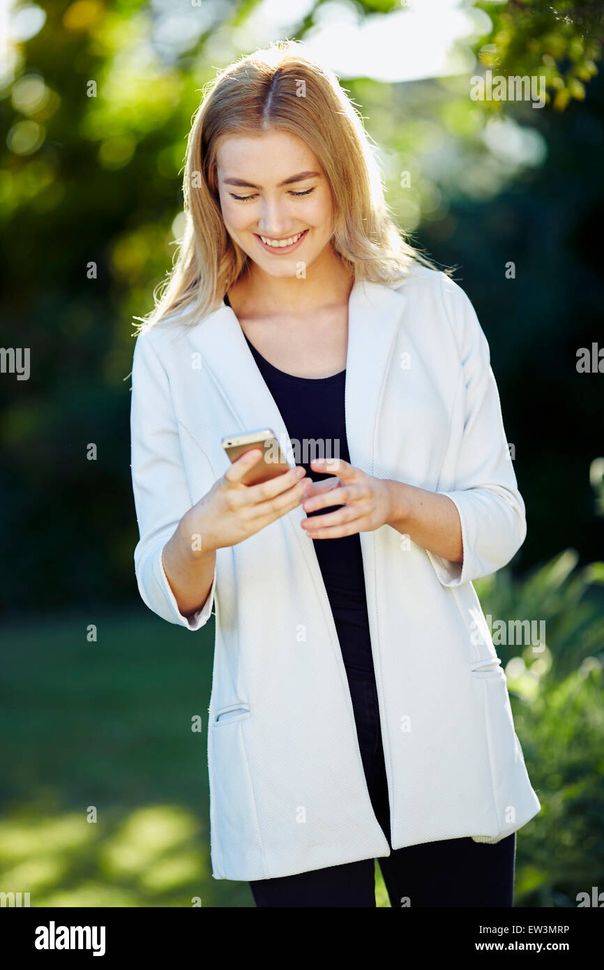 Girl reading message on her iPhone Stock Photo