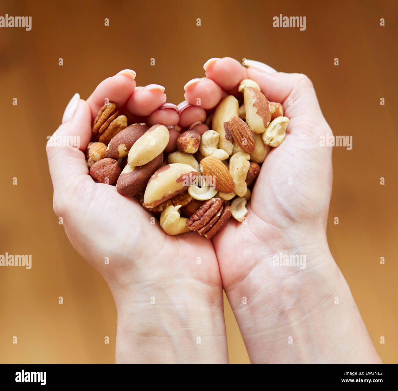 Woman holding a handful of mixed nuts Stock Photo