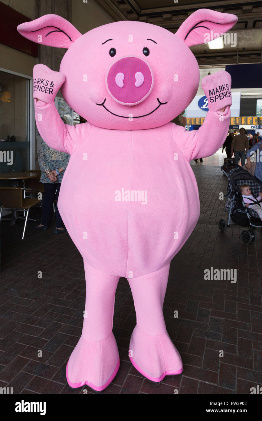 A Percy Pig mascot helps to advertise the new Marks & Spencer store on the concourse of Waterloo Station, London, UK Stock Photo