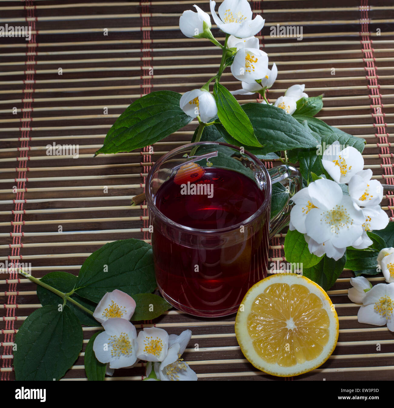 the red tea decorated with branches of the blossoming bush Stock Photo