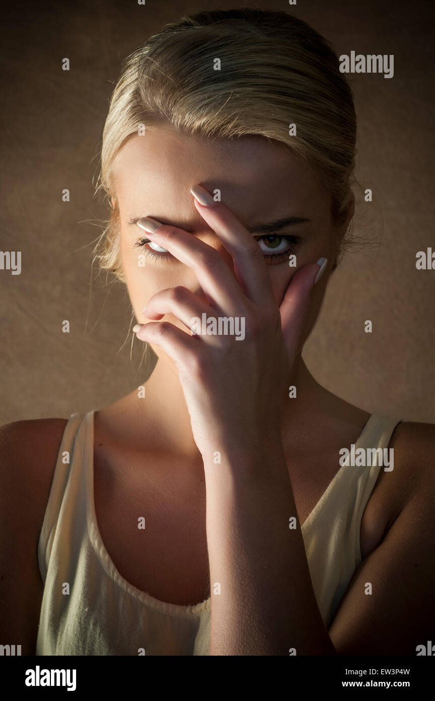 Young woman hiding face with hand Stock Photo