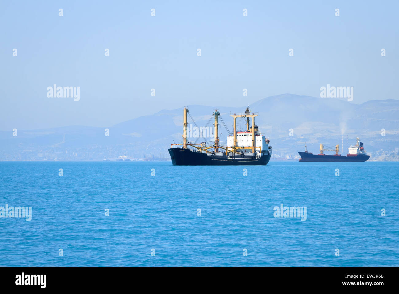 cargo ship sailing in still water near port Stock Photo