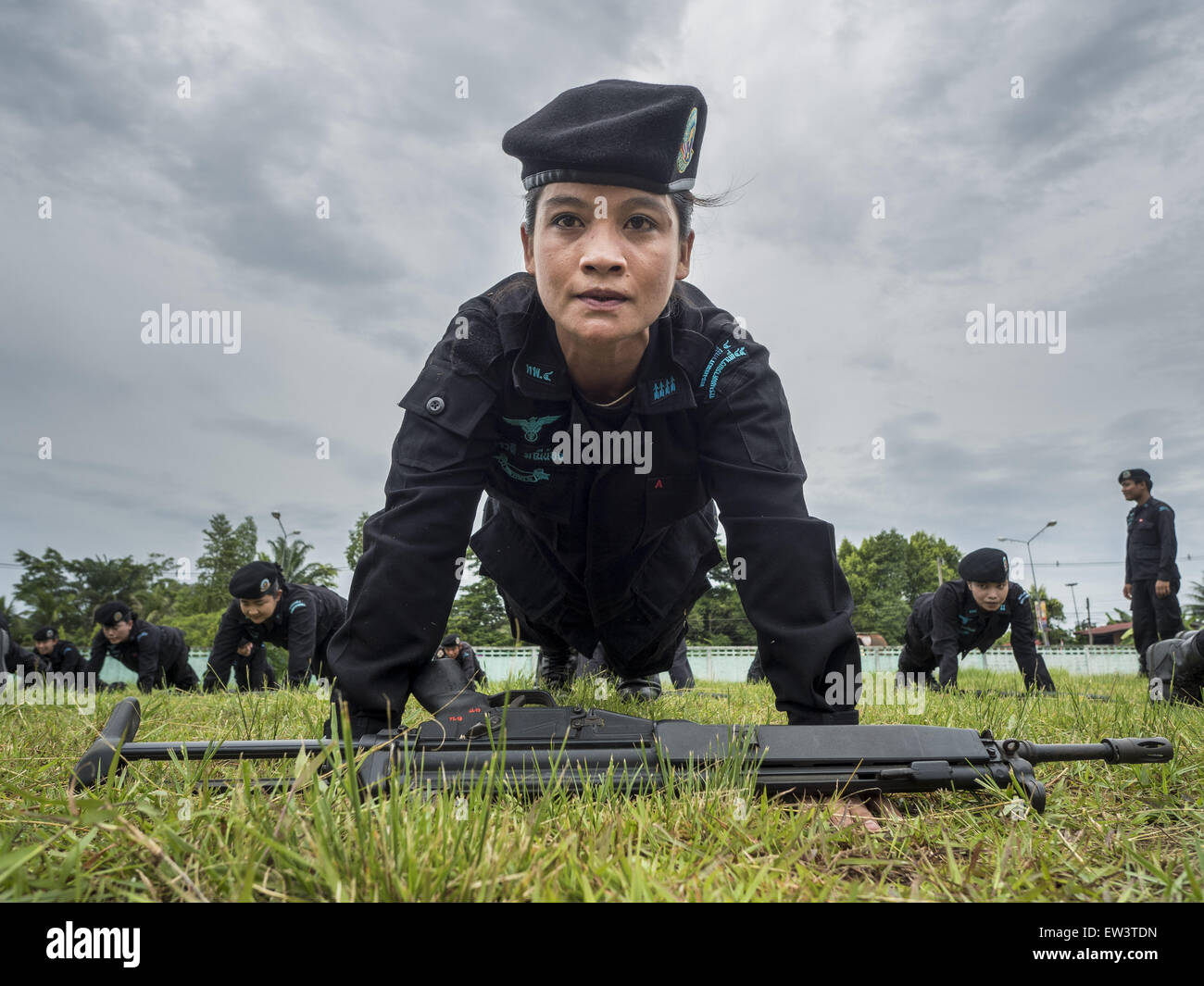 June 17, 2015 - Rangae, Narathiwat, Thailand - A Thai woman Ranger does pushup during drills at the Ranger camp in Rangae, Narathiwat province. There are 5 platoons of women Rangers serving in Thailand's restive Deep South. They generally perform security missions at large public events and do public outreach missions, like home wellness checks and delivering food and medicine into rural communities. The medics frequently work in civilian clothes because the Rangers found people are more relaxed around them when they're in civilian clothes. About 6,000 people have been killed in sectarian viol Stock Photo