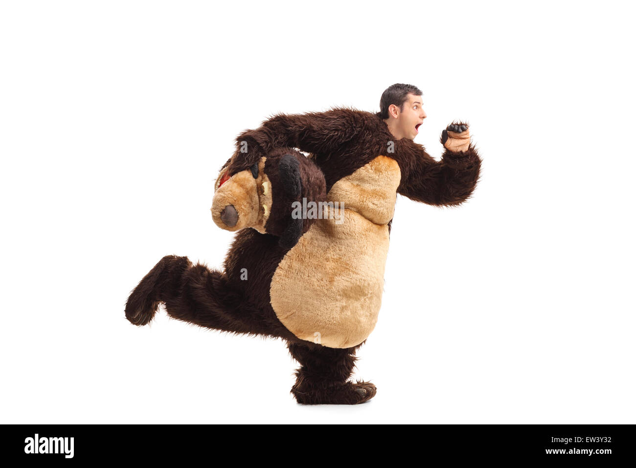 Studio shot of a horrified man in a bear costume running away from something isolated on white background Stock Photo