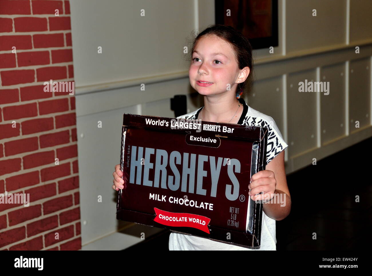 Hershey, PA:  An adorable little girl holds up one of Hershey's world's largest candy bar at the Chocolate World super store Stock Photo