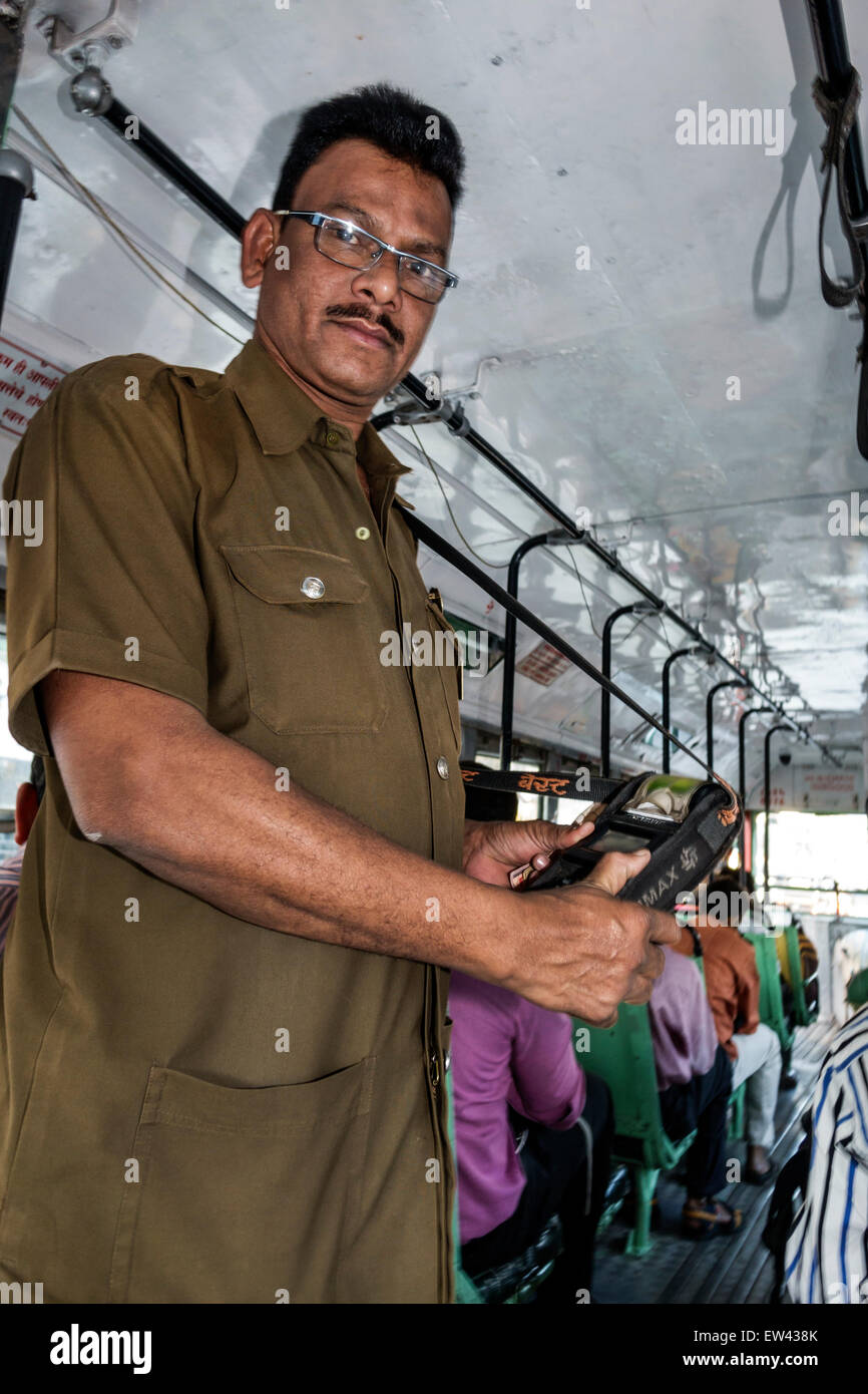 Mumbai India,Andheri East,Mathuradas Vasanji Road,BEST bus,coach,riders,passenger passengers rider riders,man men male,conductor,collecting fare,scann Stock Photo